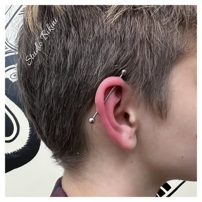 Piercing industrial w uchu dorosłej klientki Studio Bikini