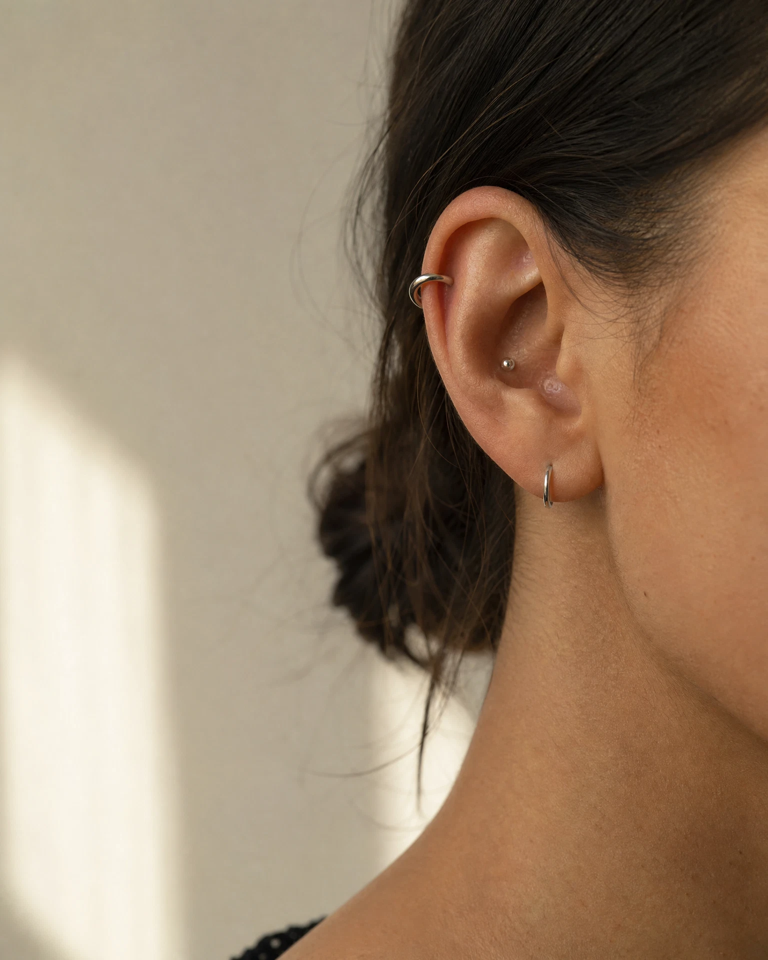 Editorialowy detal piercingu ucha z tytanową biżuterią